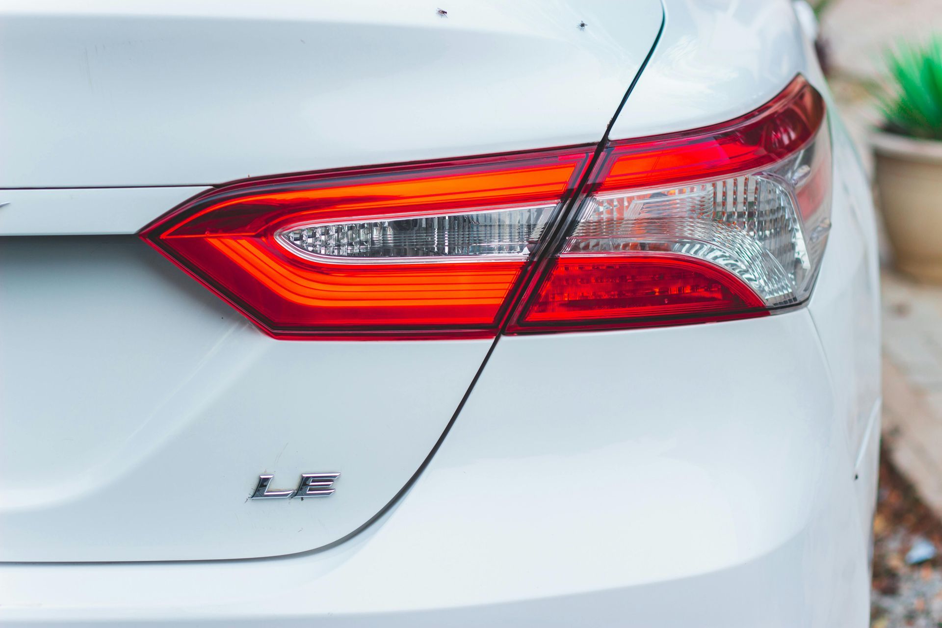 Rear view of a white car with a red taillight and LS badge