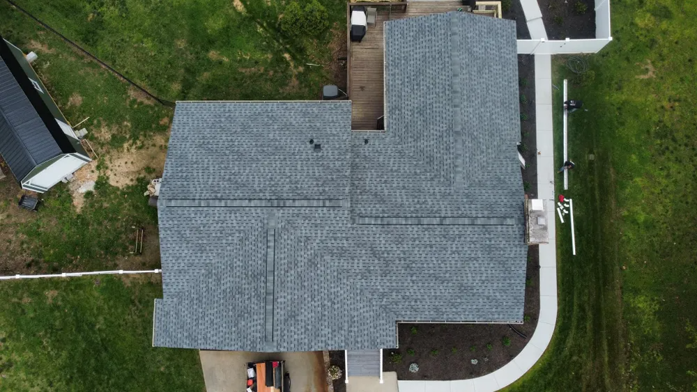Aerial view of roofing contractors repairing exposed wood roof decking on a home