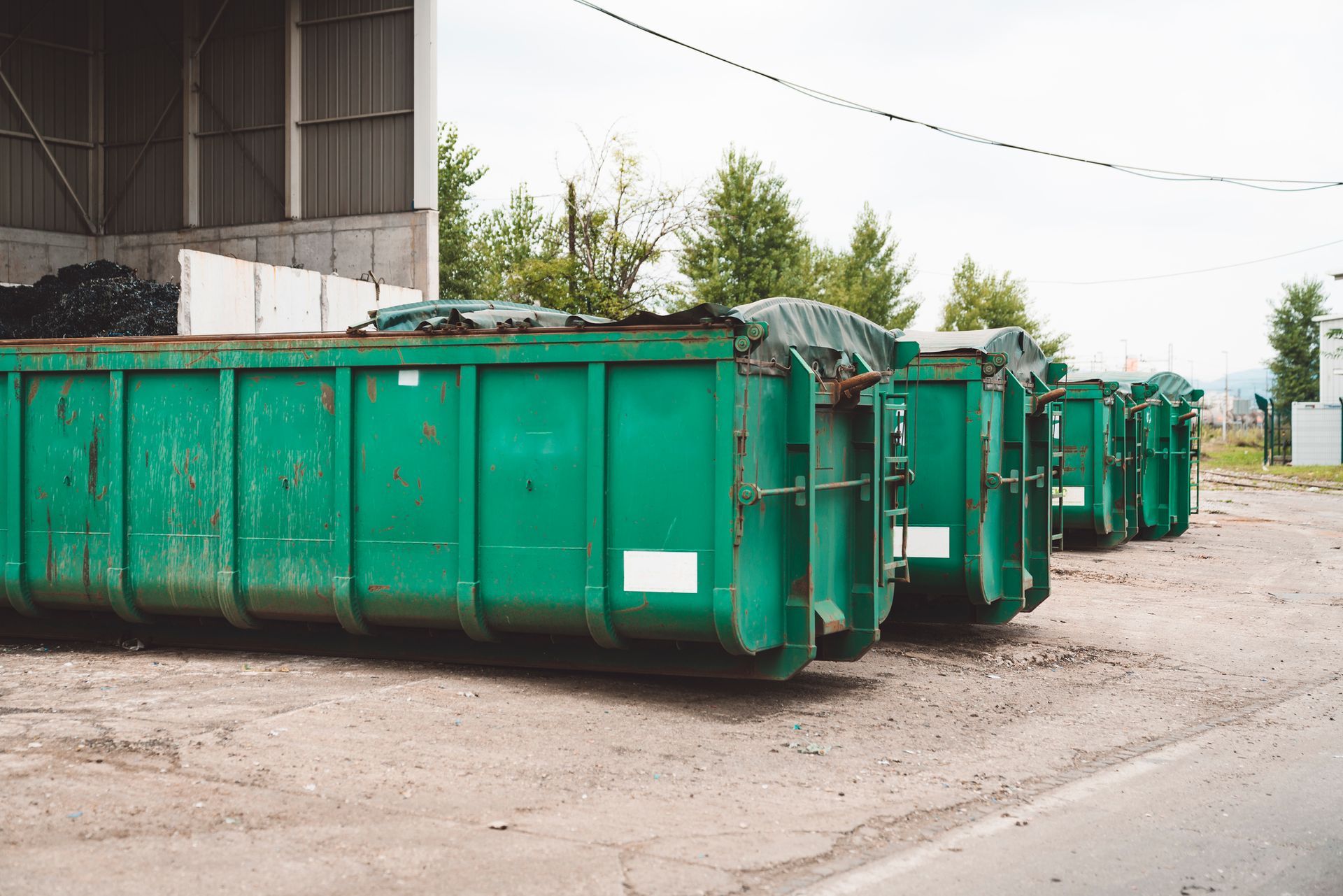 Roll-off Dumpsters filled with various waste materials, highlighting many large containers outdoors 