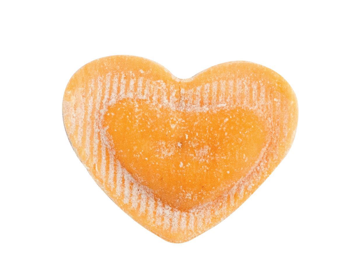 Un primo piano di un biscotto a forma di cuore su uno sfondo bianco.
