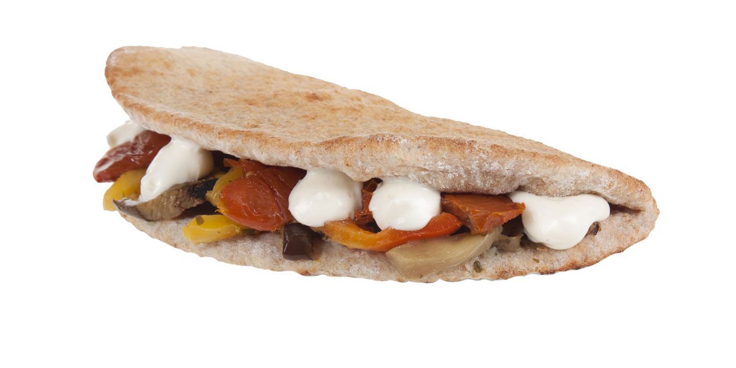 Primo piano di un panino con verdure e maionese su sfondo bianco.
