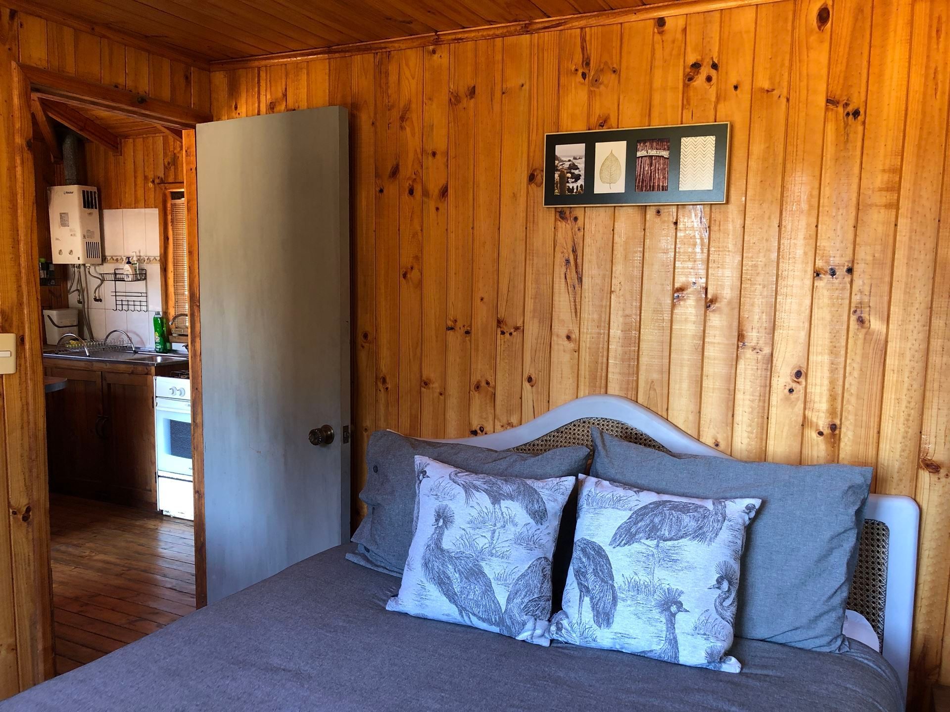 Un dormitorio con paredes revestidas de madera y una cama.