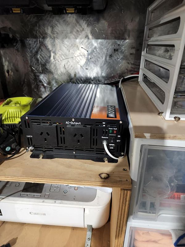 A Power Inverter Is Sitting on Top of A Wooden Shelf — Genesis Automotive Services in Lavington, NSW