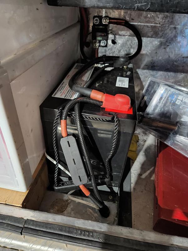 A Black Battery Is Sitting on Top of A Wooden Table — Genesis Automotive Services in Lavington, NSW