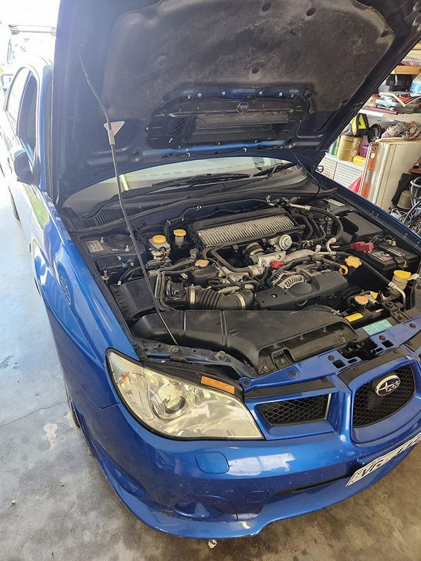 A Blue Subaru with The Hood Open Is Parked in A Garage — Genesis Automotive Services in Lavington, NSW