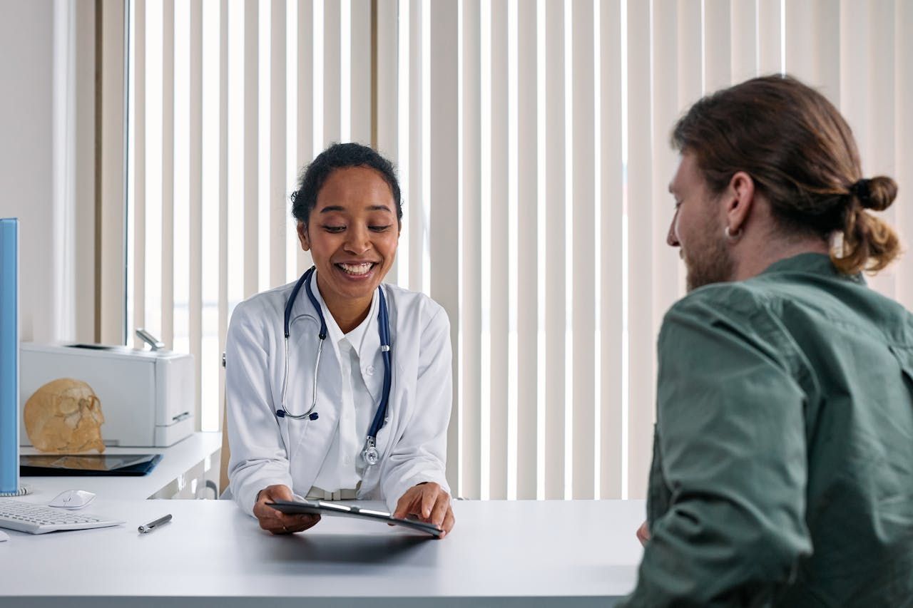 Healthcare worker in mask and gloves shaking hands with a patient in a clinic