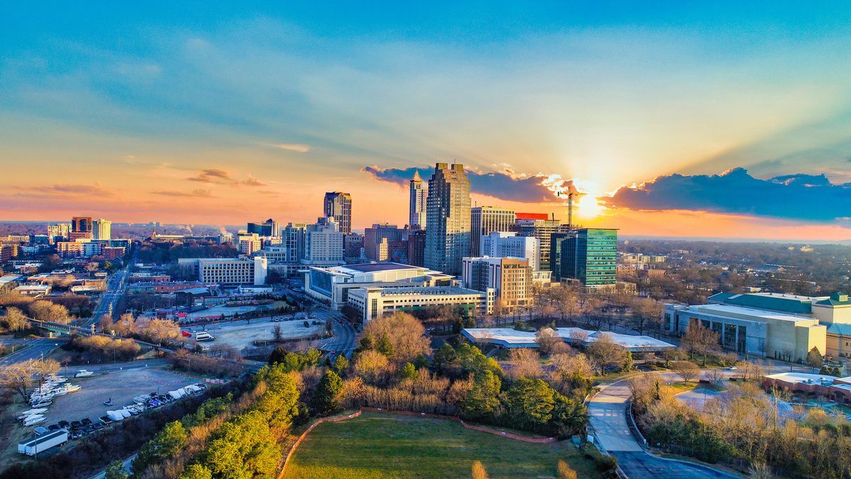 City skyline with sun behind clouds