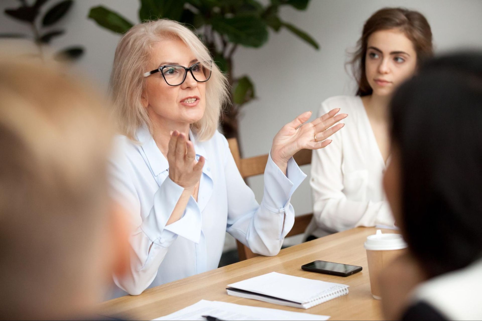 a woman with glasses speaking to a group