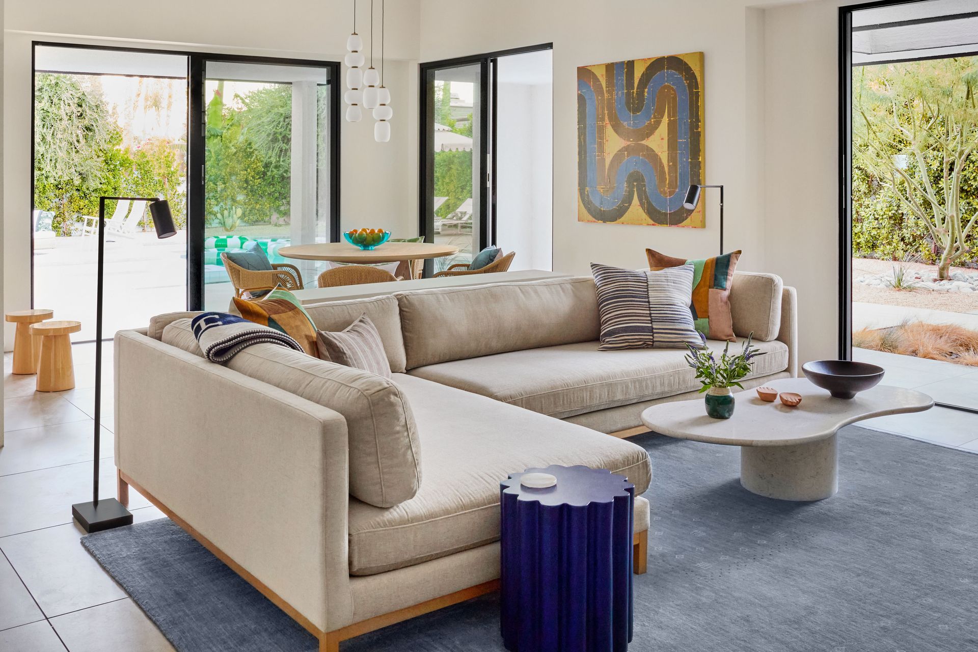 a living room with a couch , chairs , coffee table and television .