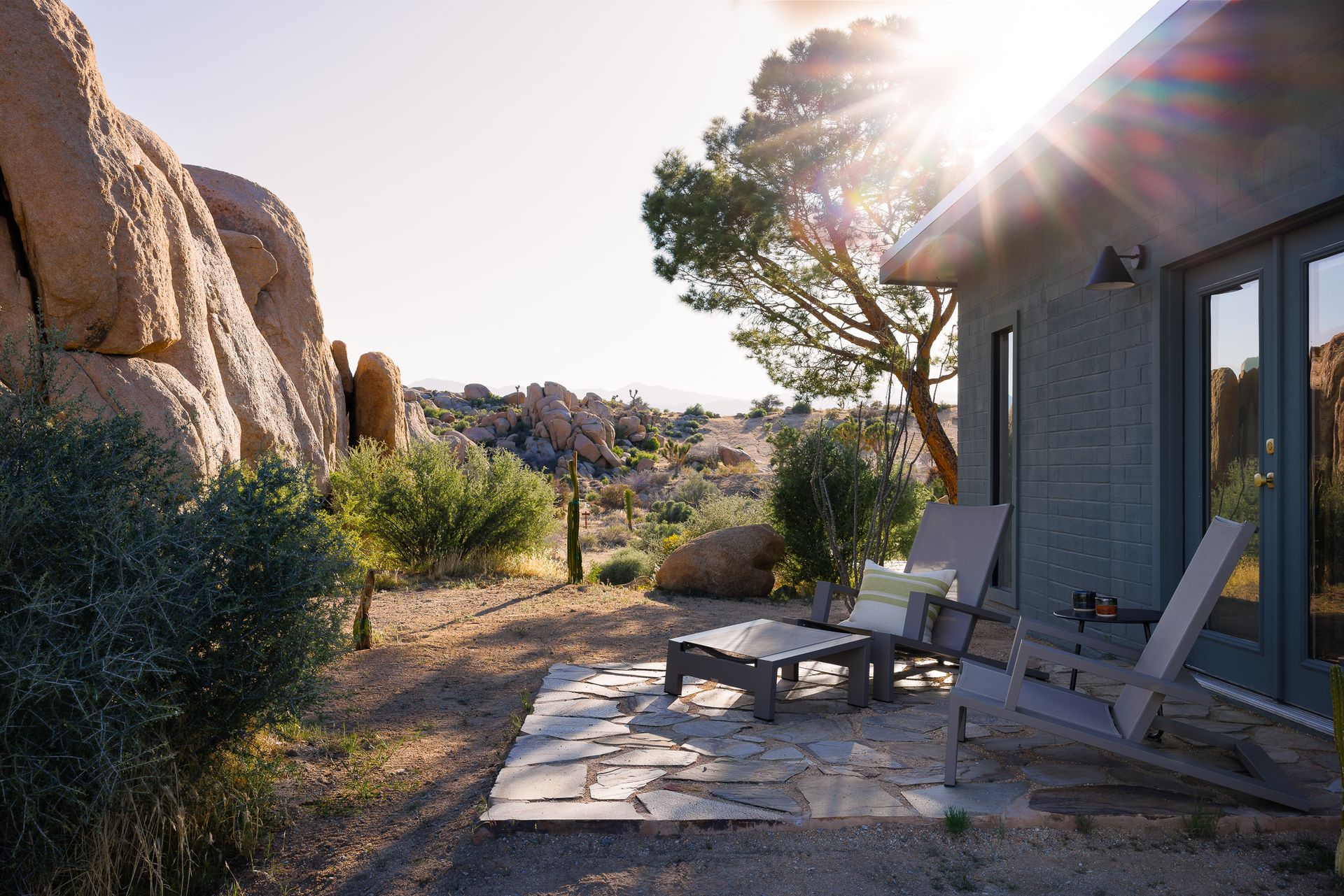 A house in the middle of a desert surrounded by rocks.