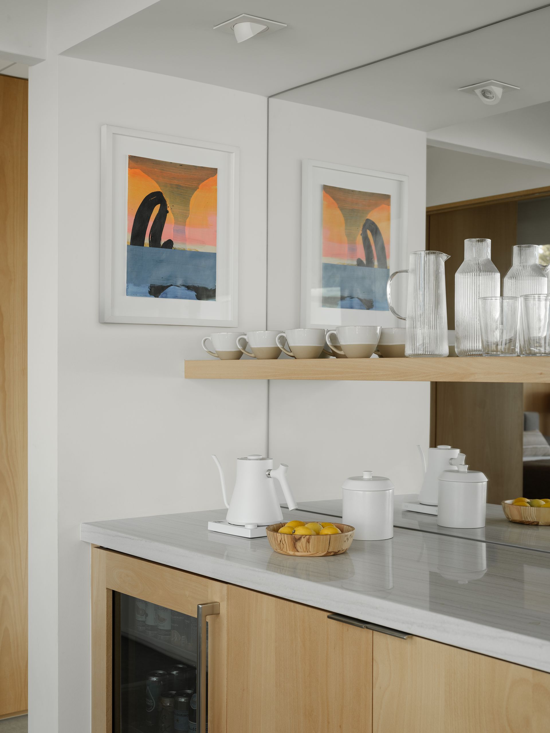a kitchen with a shelf full of bottles and cups
