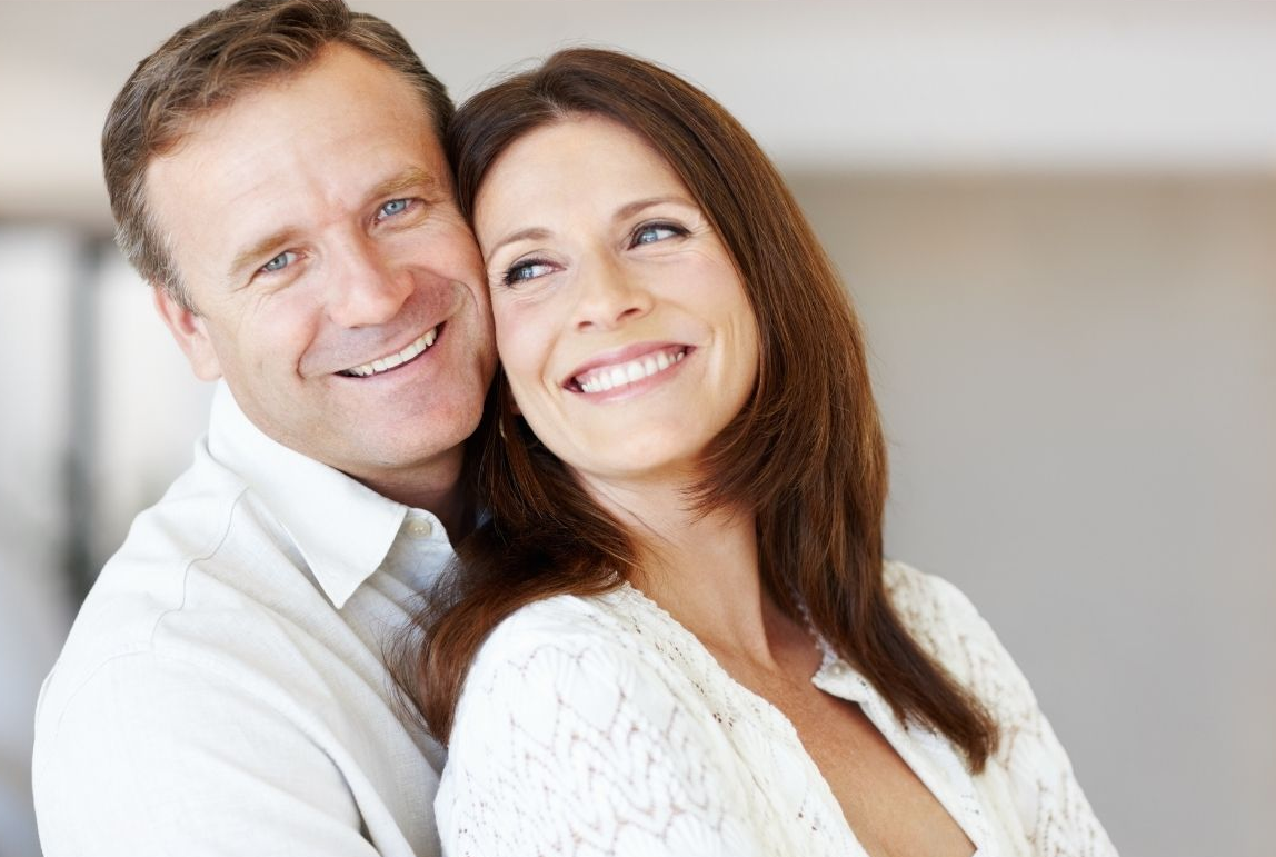 Smiling couple sitting close together in soft, bright light