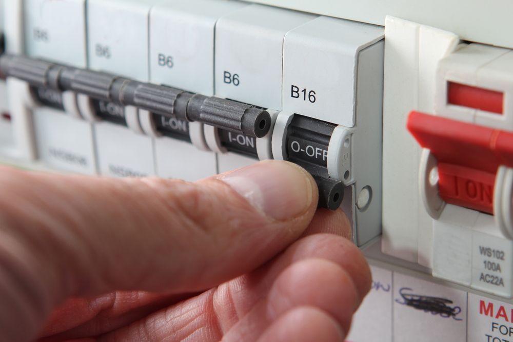A Hand Turning Off a Circuit Breaker — CKS Electrical and Air Conditioning in Ciccone, NT