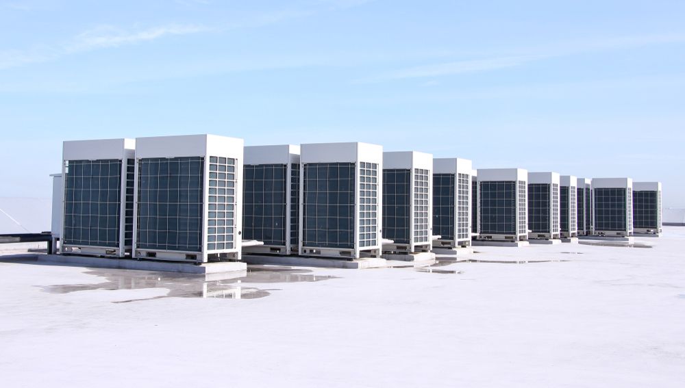 Row of Rooftop HVAC Units Against a Light Blue Sky, on a Flat Roof — CKS Electrical and Air Conditioning in Ciccone, NT