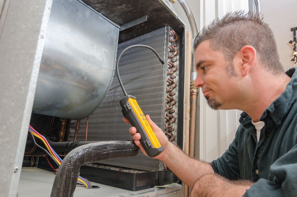 A Technician Uses a Leak Detector on an Air Conditioning Unit — CKS Electrical and Air Conditioning in Alice Springs, NT