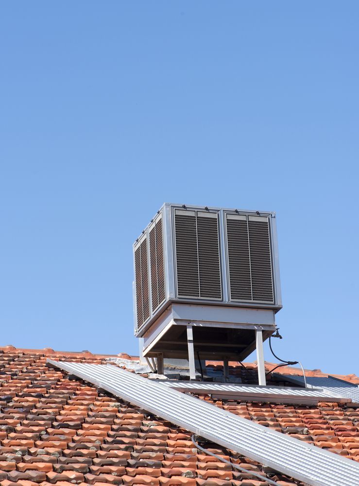 A Rooftop Air Conditioning Unit Sits on an Orange-tiled Roof — CKS Electrical and Air Conditioning in Ciccone, NT