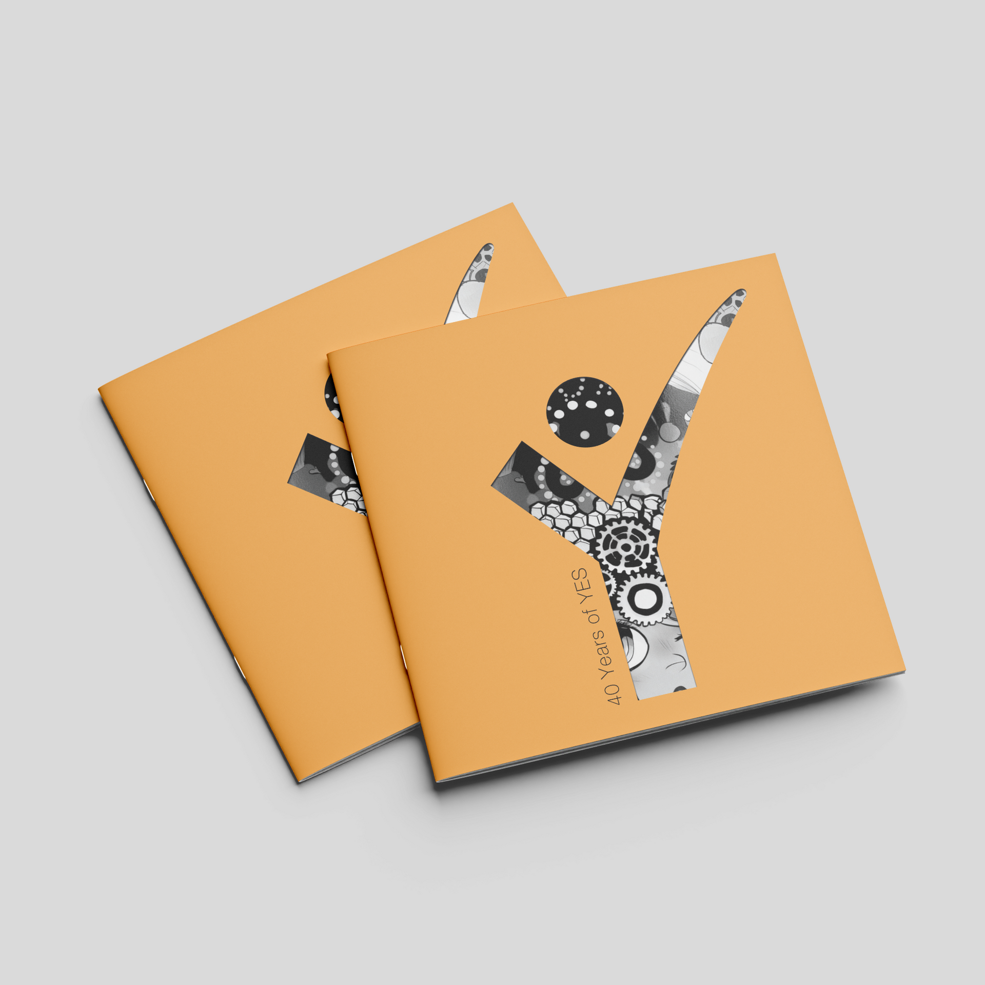 Two orange notebooks with abstract white and black cover designs on a gray background