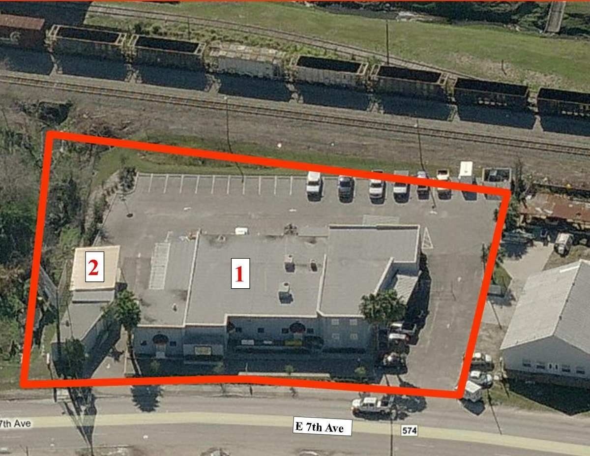 Aerial view of a building outlined in red with numbered markers and parked cars nearby.