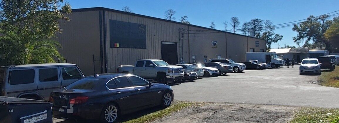 Industrial building with parked cars in a sunny lot