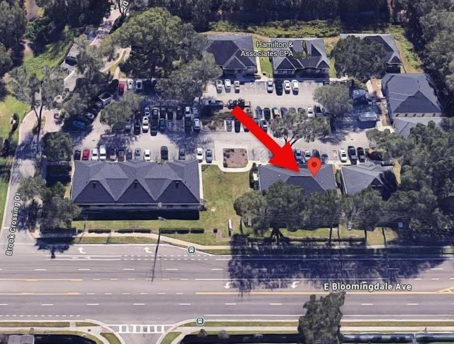 Aerial view of a parking lot and apartment buildings, with a red arrow pointing to one parking space