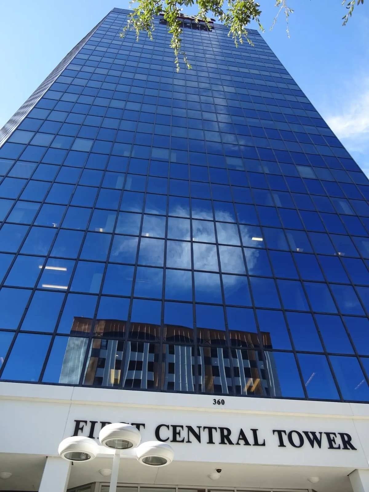 Skyscrapers under a bright blue sky, with reflections in the glass windows.