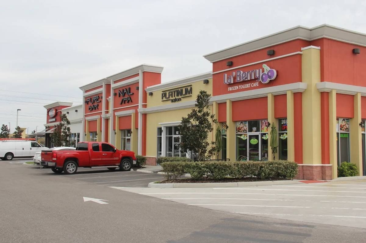 Orange and beige restaurant building with a red pickup truck parked outside