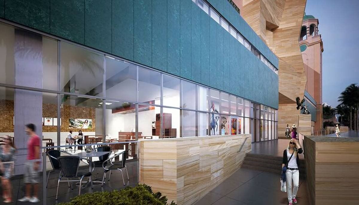 Modern glass-fronted restaurant with outdoor seating and a few people on a city street at dusk