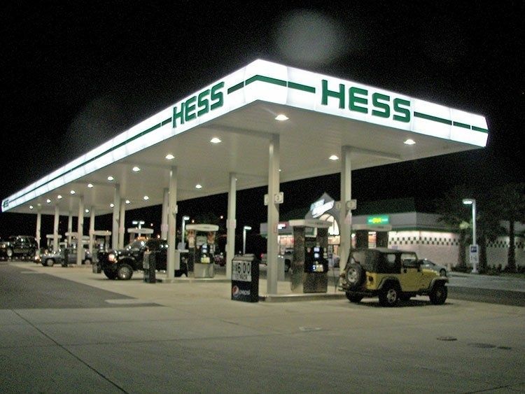 Hess gas station at night with several vehicles parked under the bright canopy