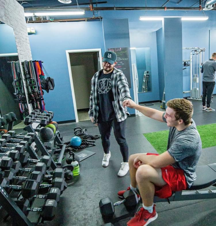 Personal trainer coaching client through strength workout at Hustle & Heart Fitness Overland Park KS