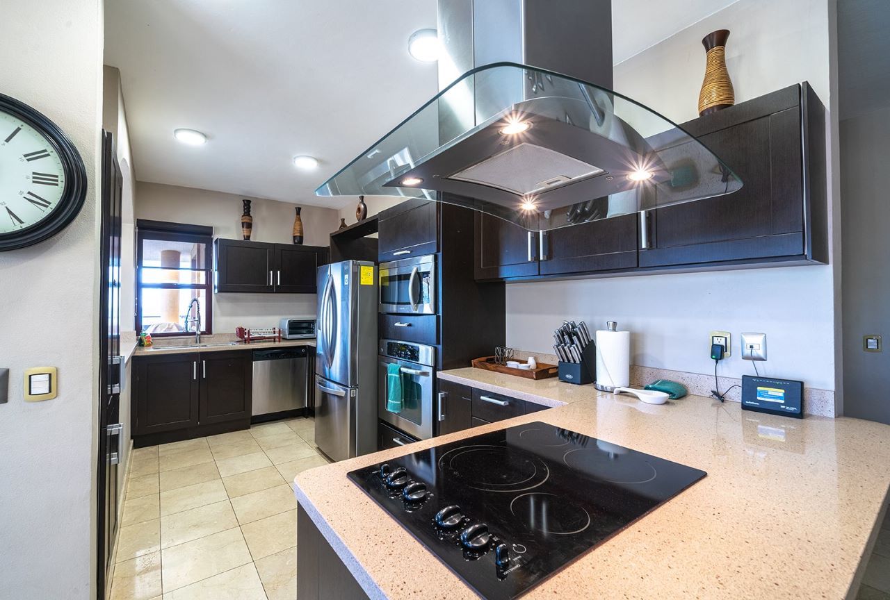 Modern kitchen with dark cabinets, stainless steel appliances, and granite countertops.