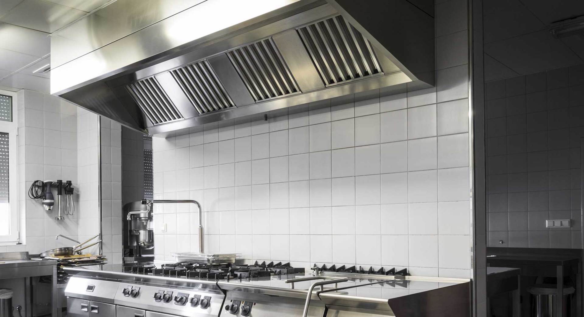 A kitchen with stainless steel appliances and white tiles
