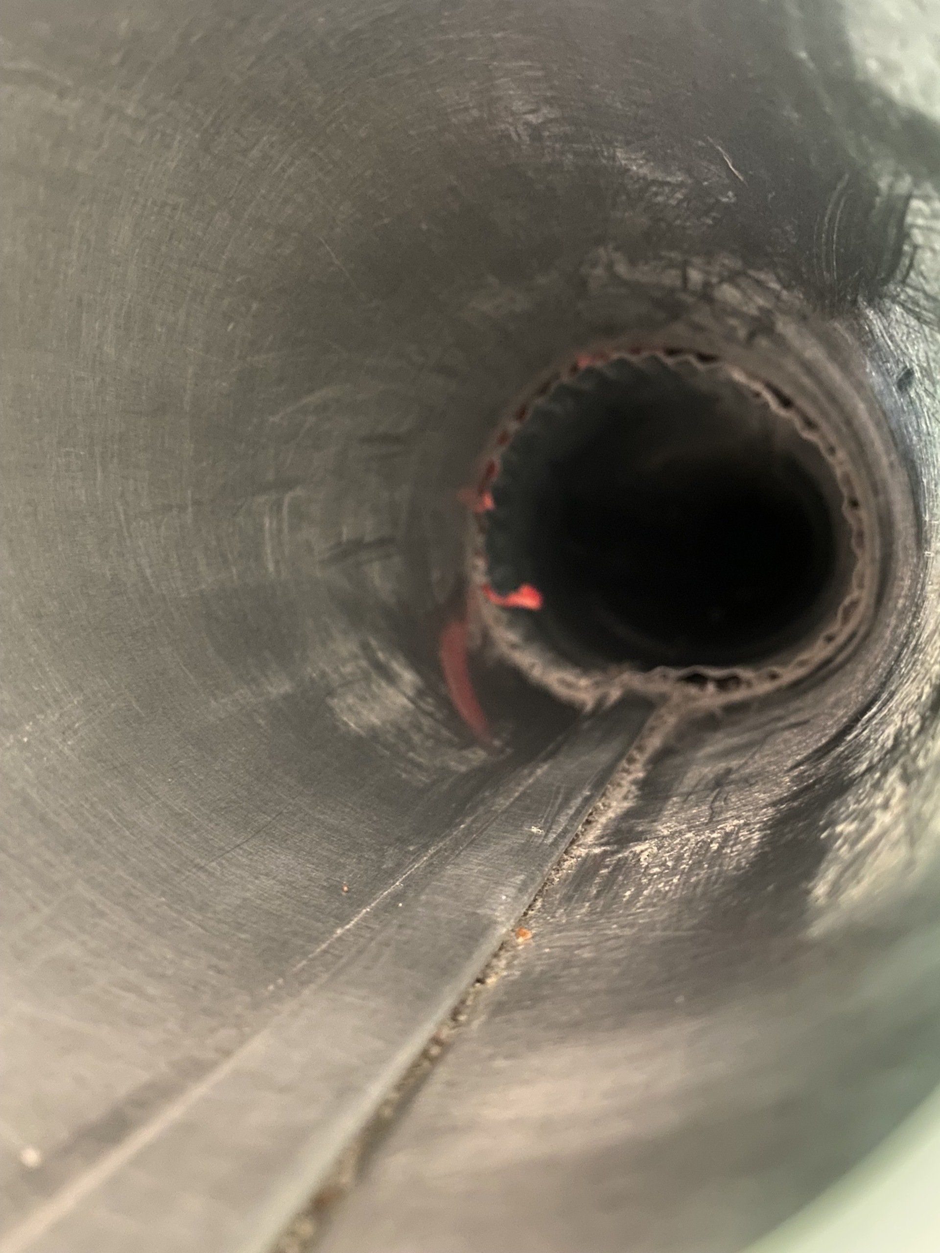 A close up of a hole in a metal pipe.