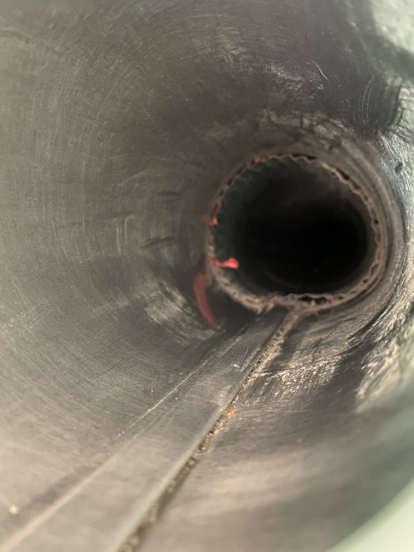 A close up of a hole in a metal pipe.