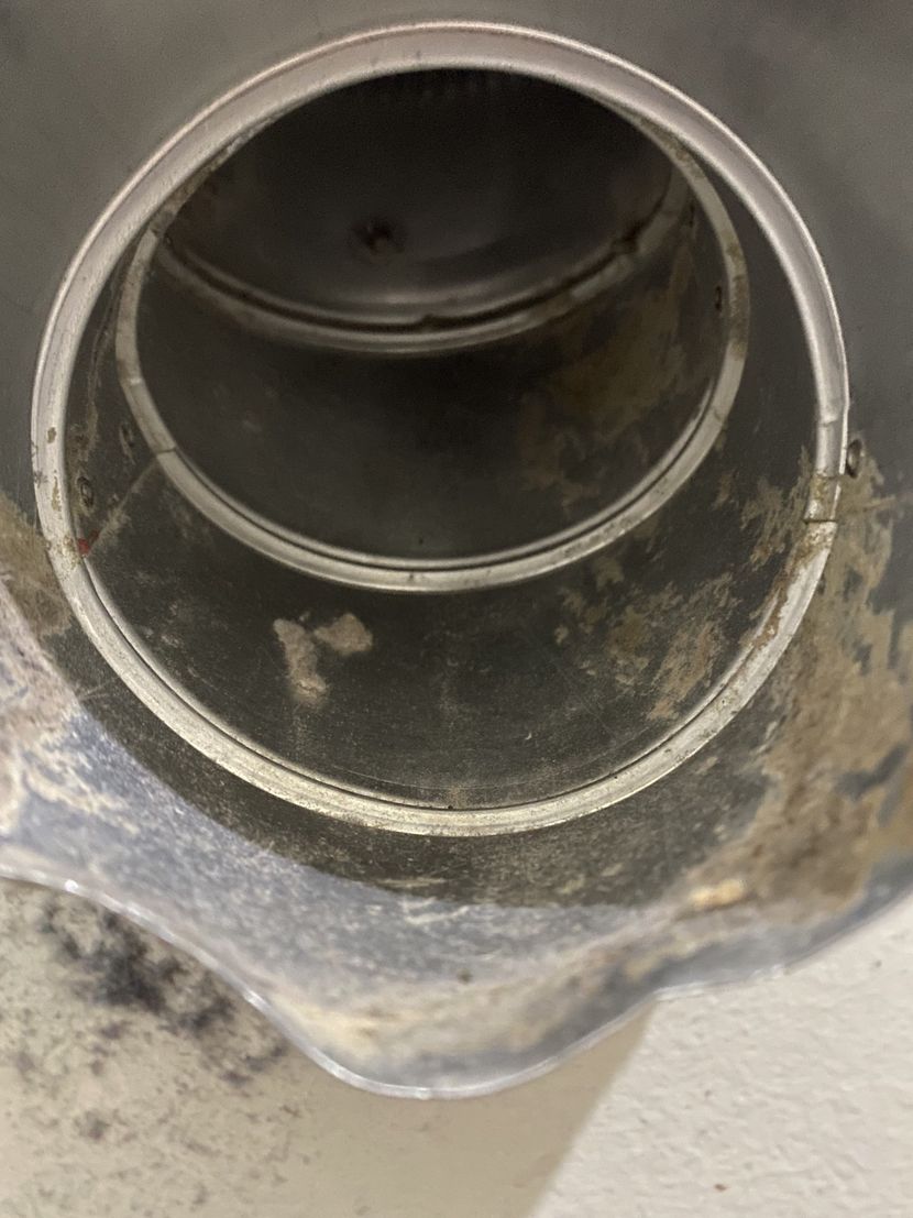 A close up of a metal pipe with a hole in it