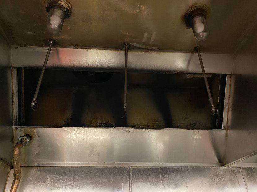 A close up of a stainless steel exhaust hood in a kitchen.