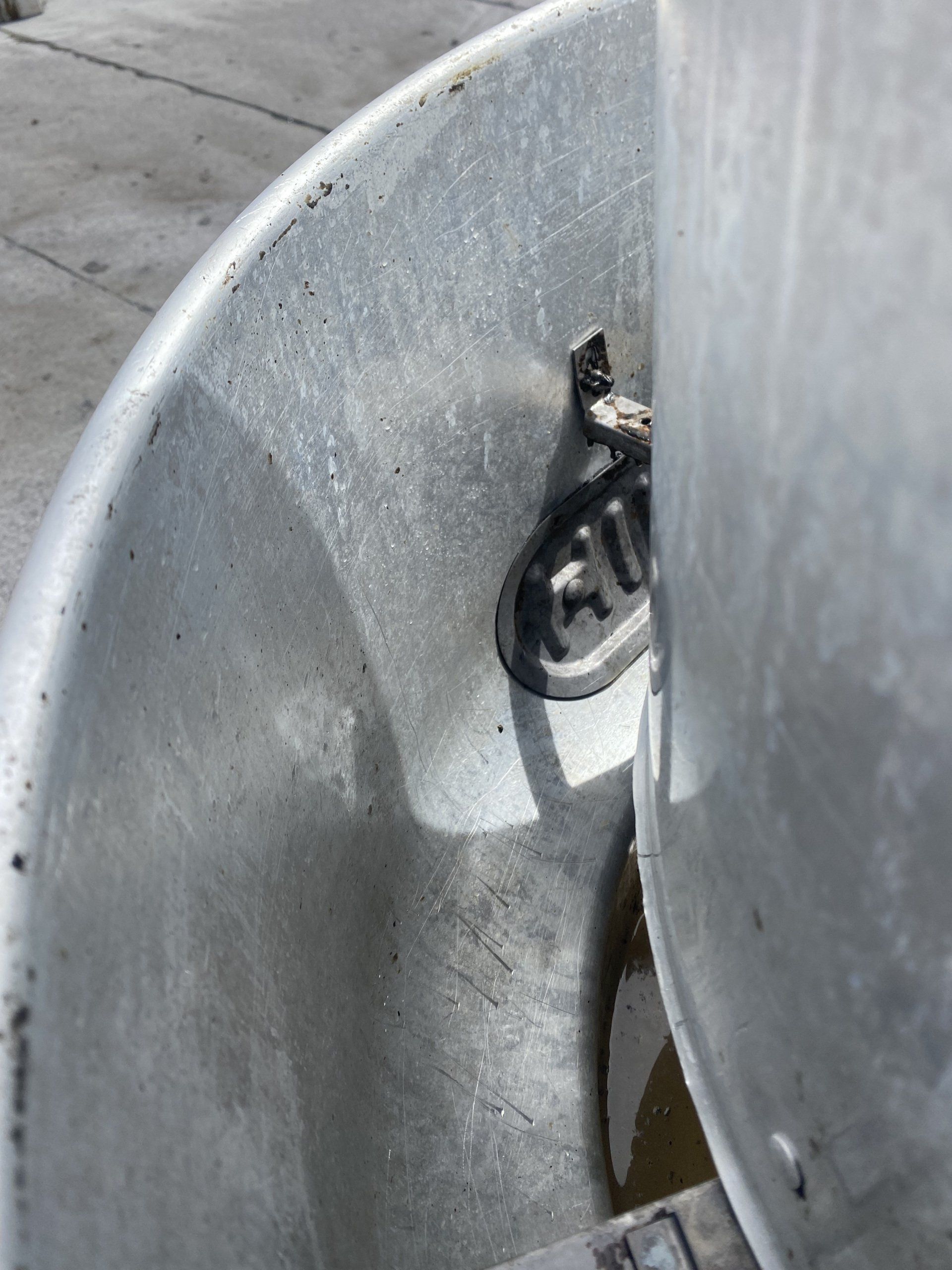 A close up of a metal bucket on a concrete surface.