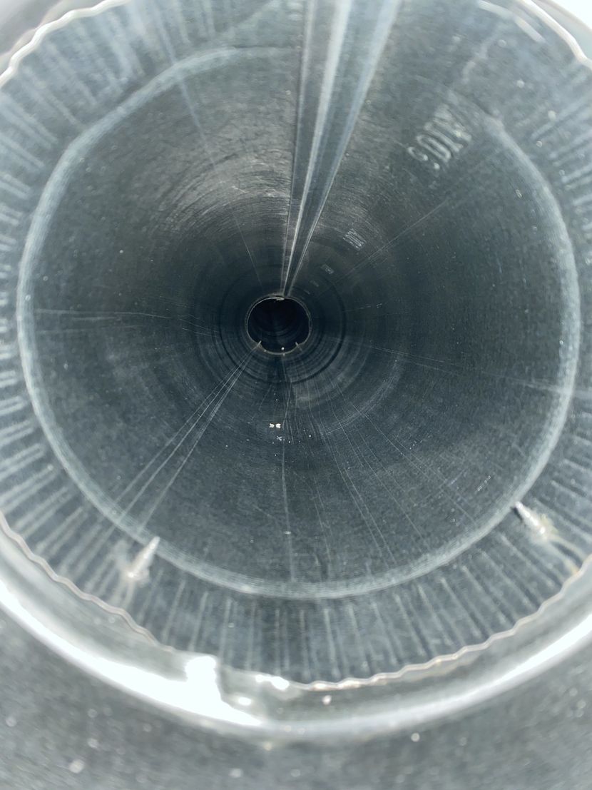 A close up of a metal pipe with a hole in the middle