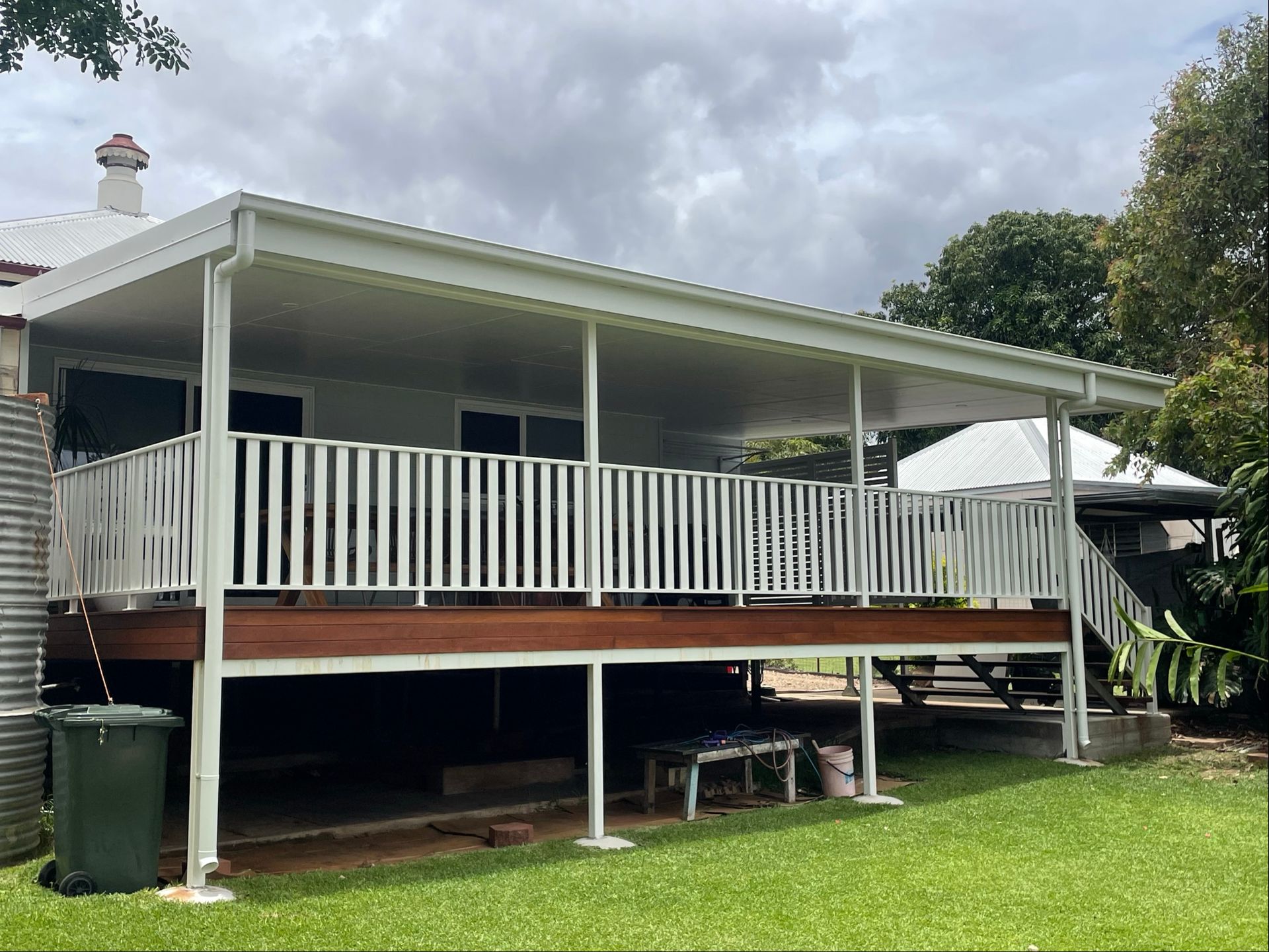 White deck with railing, attached to a white house, under a covered patio. Overcast sky — Lifestyle Aluminium Lattice in West End, QLD