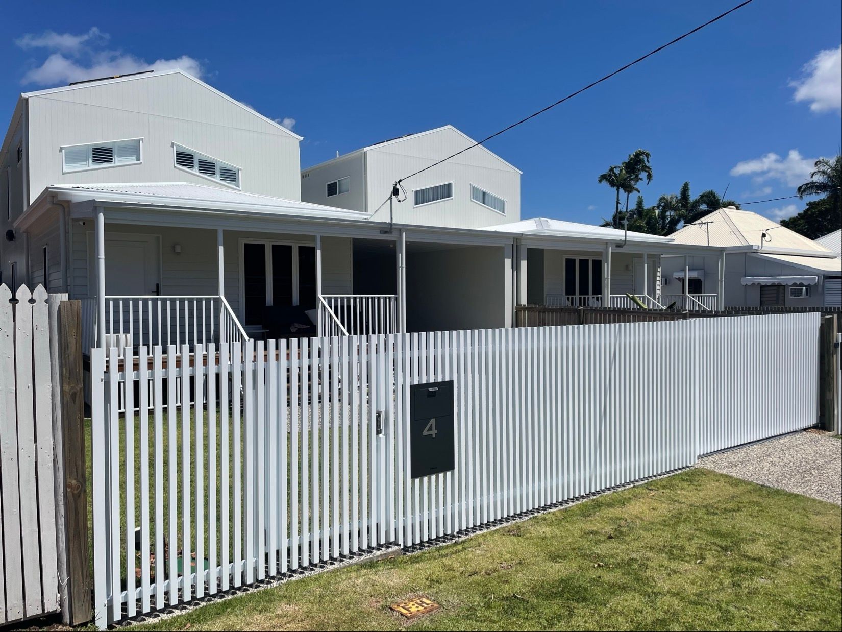 White houses behind a white picket fence, sunny day. House number 4 on mailbox — Lifestyle Aluminium Lattice in West End, QLD
