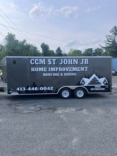 Gray CCM ST. JOHN JR Home Improvement roofing and siding trailer parked outdoors with phone number 413-446-0042