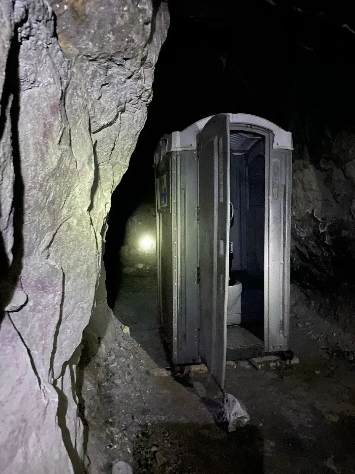 Un baño portátil está en el medio de una mina.