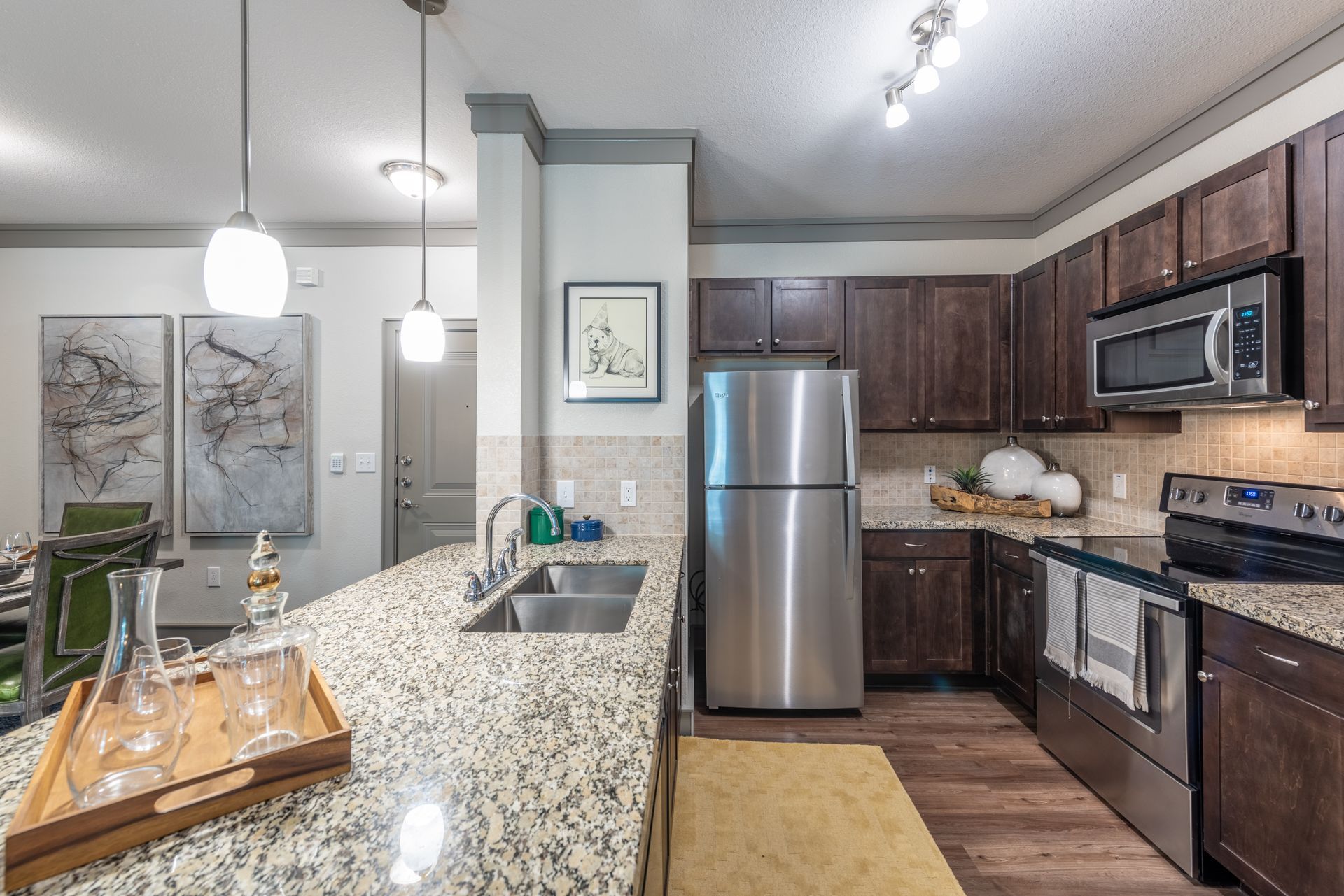 A kitchen with stainless steel appliances & granite counter tops at Marquis Seven Lakes, offers pet-friendly apts in Katy.