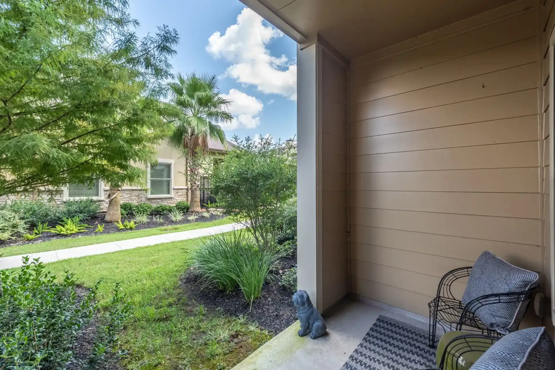 There is a patio with a chair and a statue of a squirrel on it at Marquis Seven Lakes offers apartments with private patio/balcony in Katy, TX.