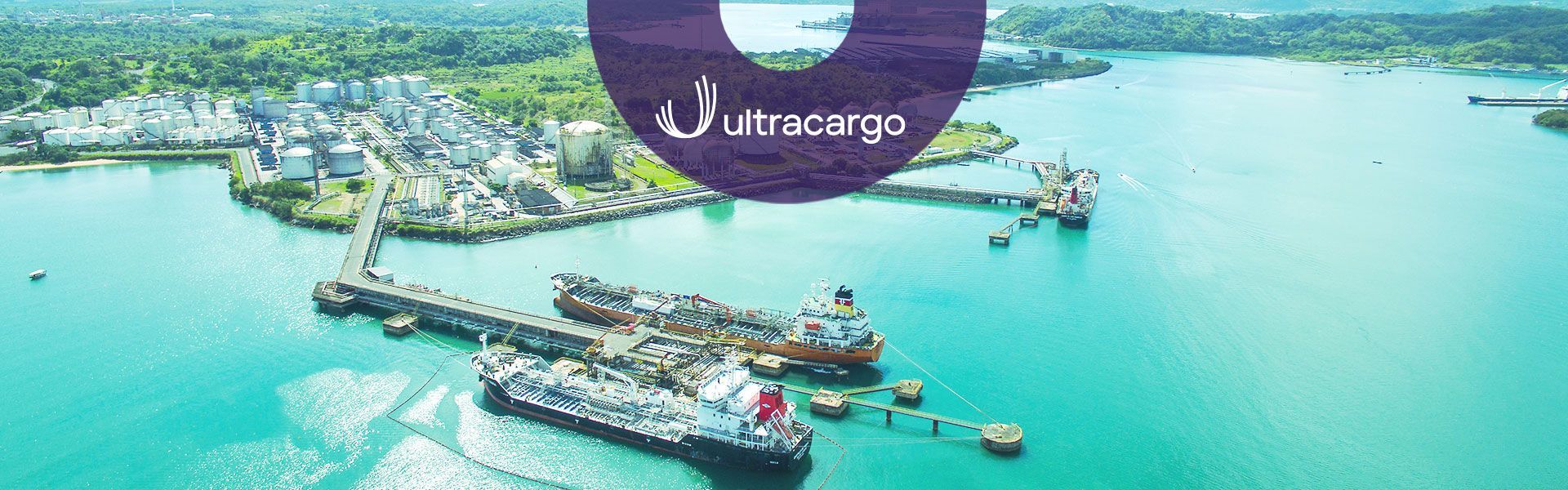Vista aérea de navios sendo carregados no porto, com tanques de armazenamento de gás ao fundo. Logo da Ultracargo.