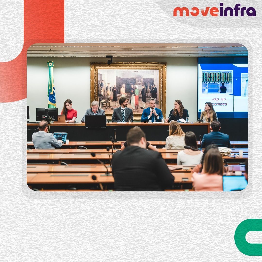 Um grupo de pessoas está sentado em mesas em uma sala com a palavra move infra na parte inferior