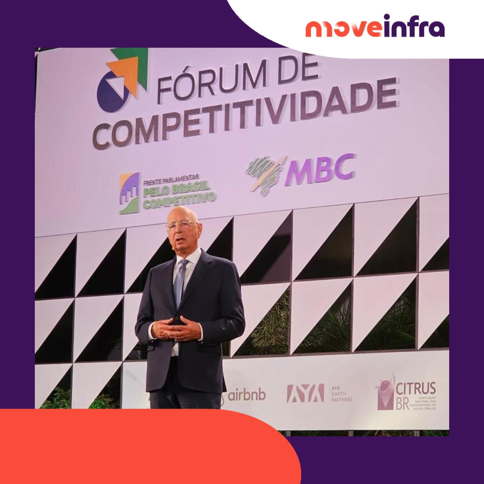um homem está em frente a uma placa que diz forum de competitividade