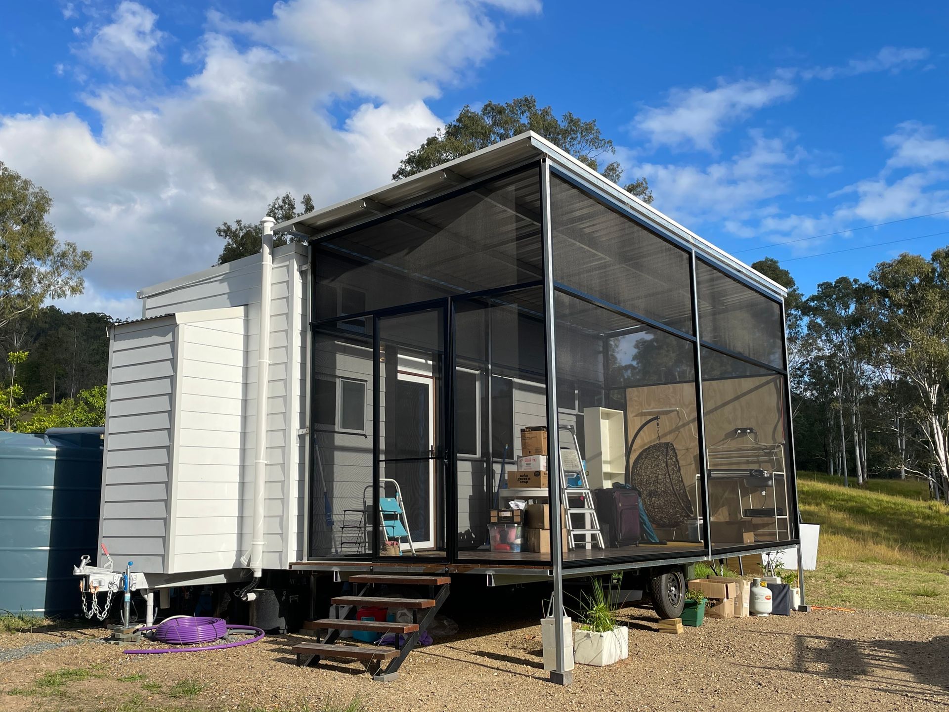 Screened mesh patio enclosure on deck of tiny home