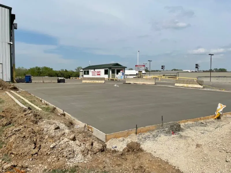 A concrete driveway is being built in front of a building.