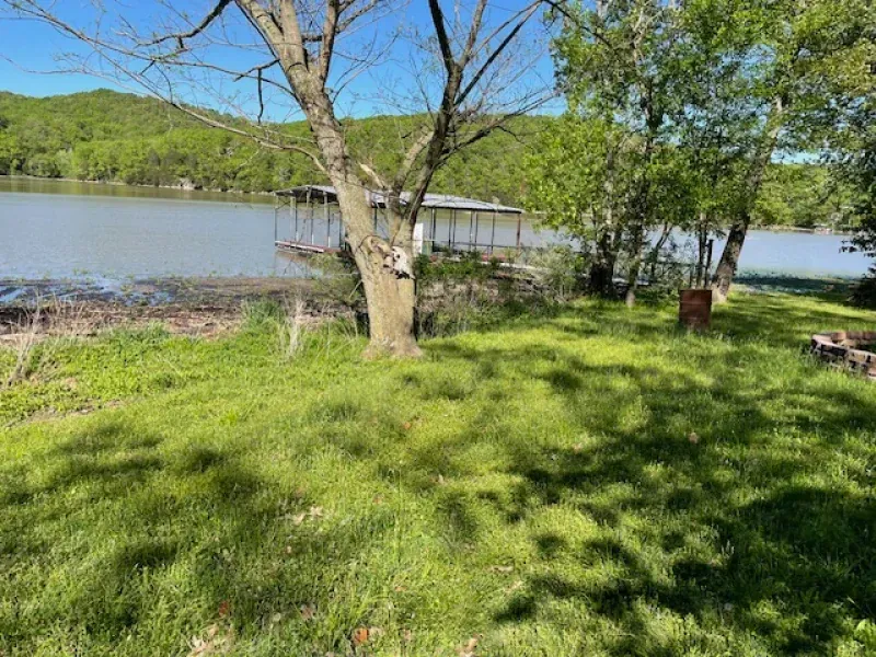 A dock is sitting on the shore of a lake surrounded by trees.
