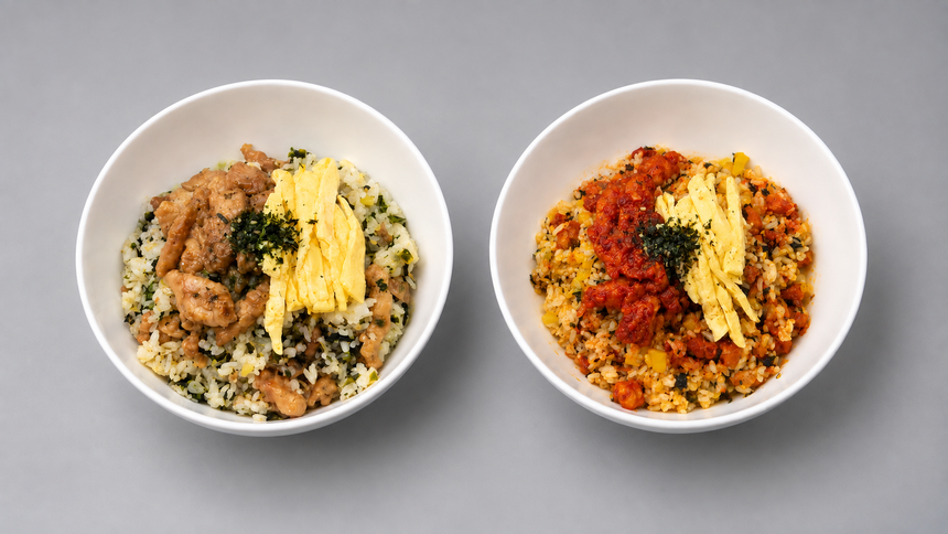 Two bowls of Korean bibimbap-style rice with colorful toppings and sauce on a gray table